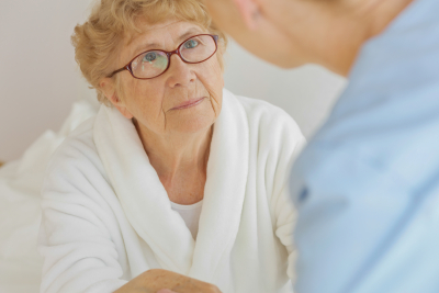 caregiver assisting the senior woman with ASD