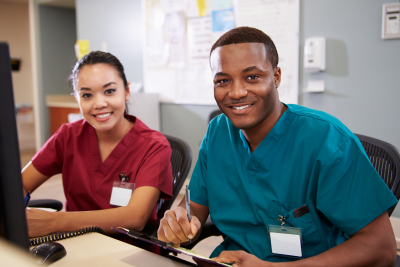 two nurses are smiling at the nursing station