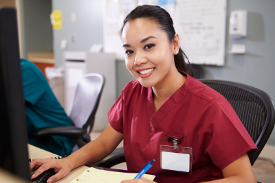 female nurse smiling at the nursing station