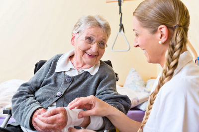 Nurse taking care of senior bandaging a wound