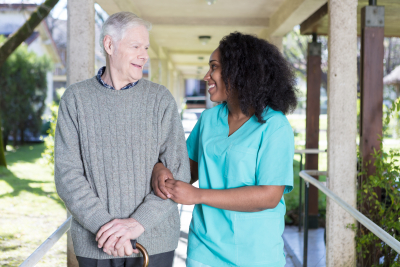 caregiver and senior man are walking at the outdoor